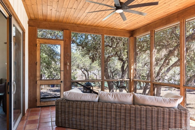 unfurnished sunroom featuring wood ceiling and a ceiling fan