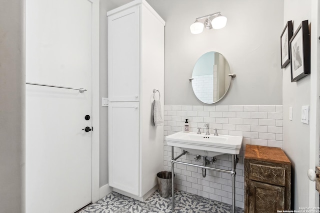 bathroom featuring a sink and tile walls