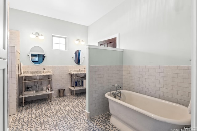 full bath featuring wainscoting, a freestanding bath, and tile walls