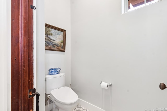 bathroom featuring toilet and baseboards