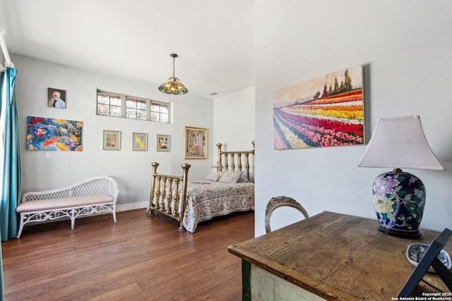 bedroom featuring baseboards and dark wood-type flooring