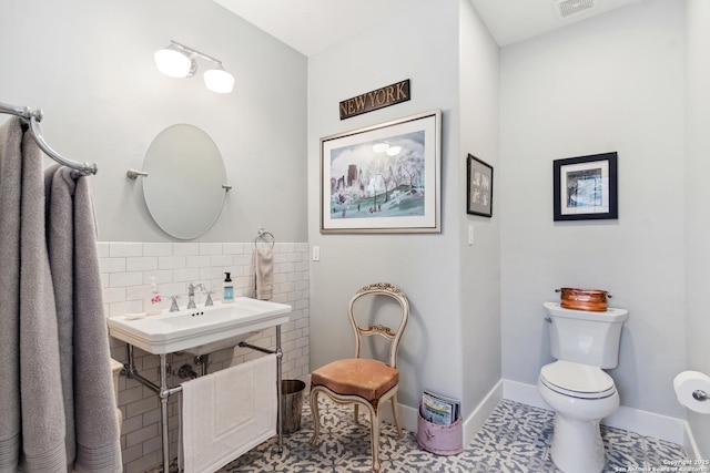 bathroom featuring visible vents, baseboards, a sink, tile patterned flooring, and toilet