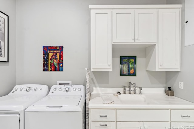 washroom featuring a sink, cabinet space, and separate washer and dryer