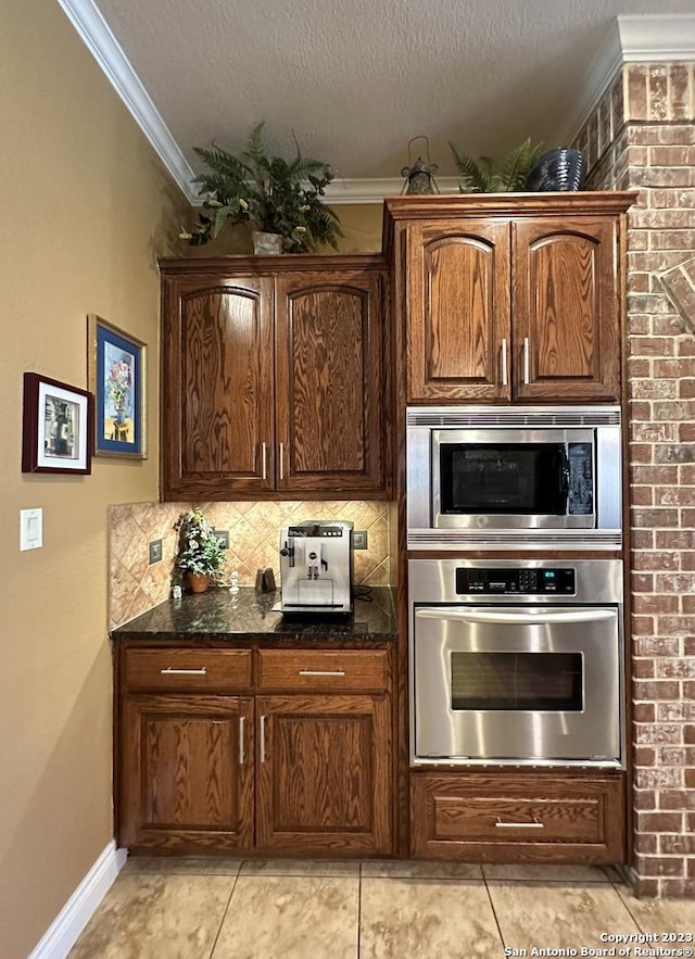 kitchen featuring crown molding, backsplash, appliances with stainless steel finishes, and a textured ceiling