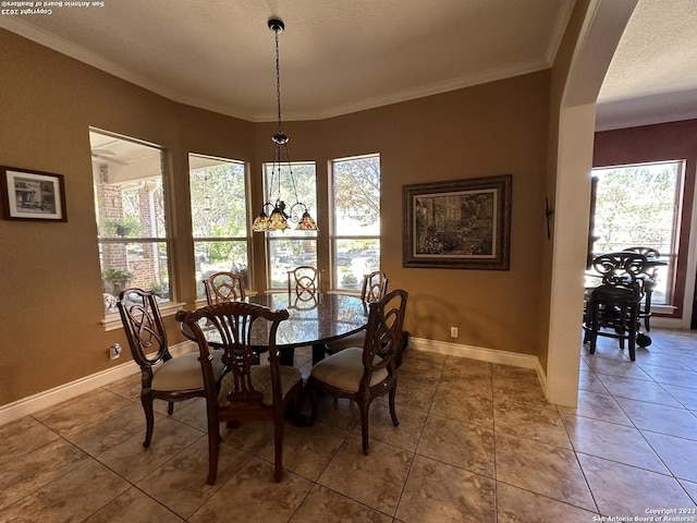 dining space with light tile patterned floors, baseboards, arched walkways, and ornamental molding