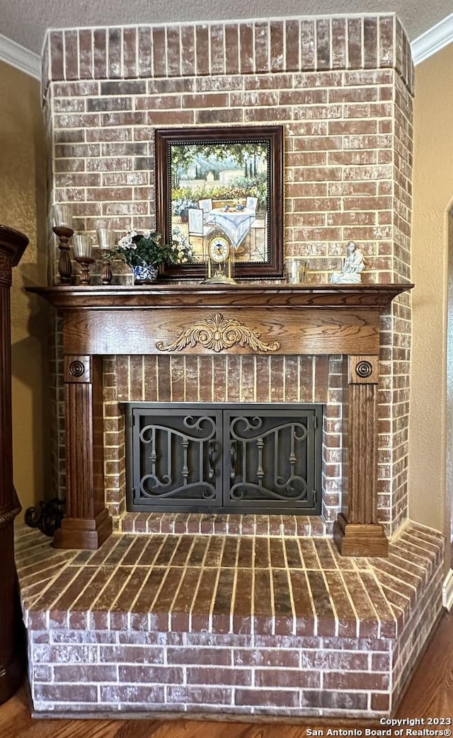 room details featuring a fireplace, a textured ceiling, and ornamental molding