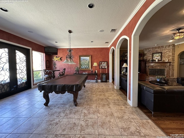 playroom featuring visible vents, a textured ceiling, and ornamental molding