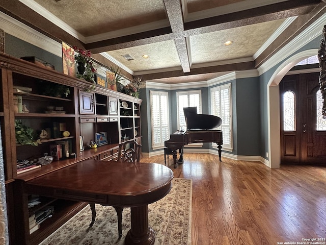 office space with arched walkways, coffered ceiling, a healthy amount of sunlight, and wood finished floors