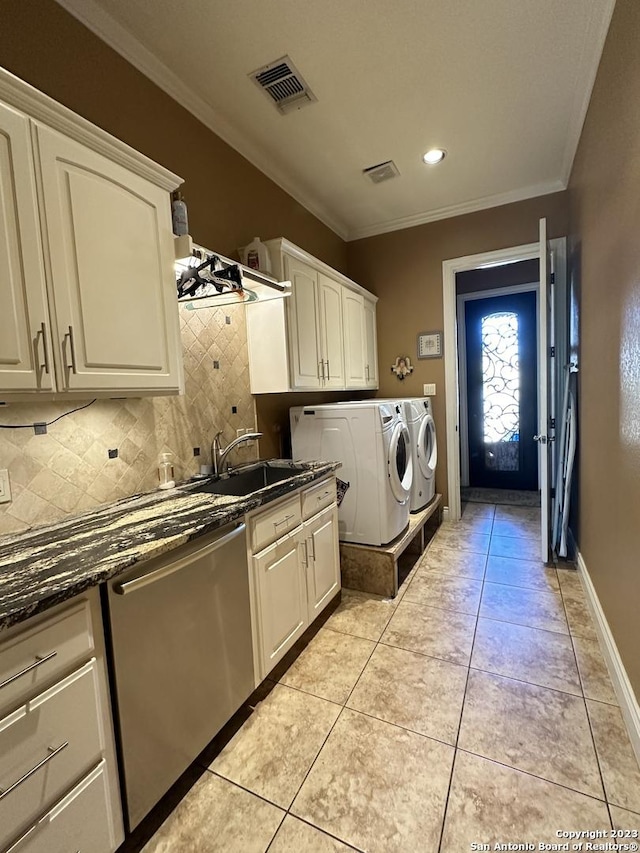 laundry area featuring visible vents, washing machine and clothes dryer, cabinet space, a sink, and ornamental molding