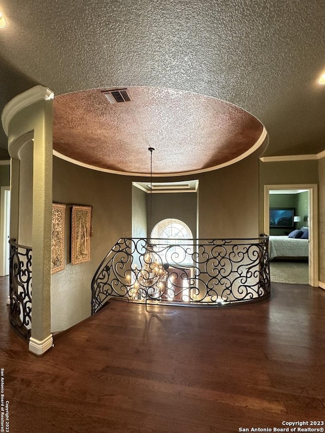 dining area with visible vents, a textured ceiling, wood finished floors, and crown molding