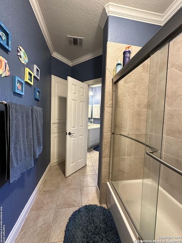 full bathroom with visible vents, a textured ceiling, crown molding, tile patterned flooring, and baseboards