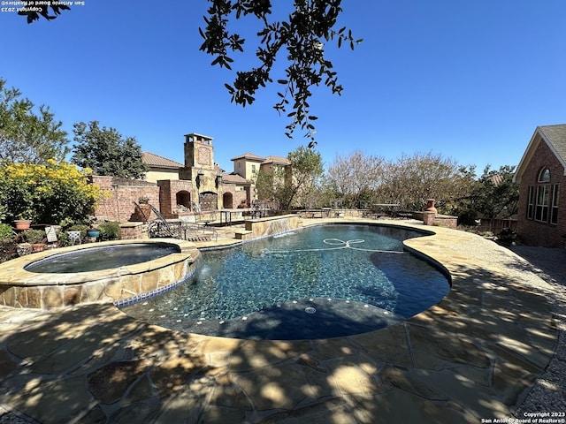 view of swimming pool featuring a patio, an outdoor stone fireplace, and fence