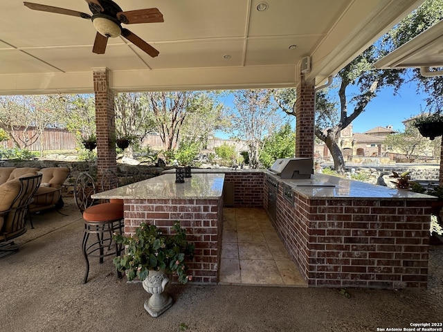 view of patio featuring grilling area, fence, exterior kitchen, outdoor wet bar, and a ceiling fan