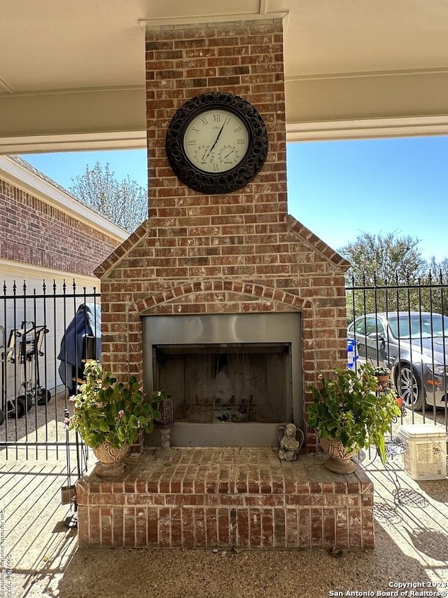 exterior details featuring brick siding and an outdoor brick fireplace