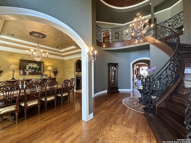 dining room featuring arched walkways, a chandelier, stairway, and visible vents