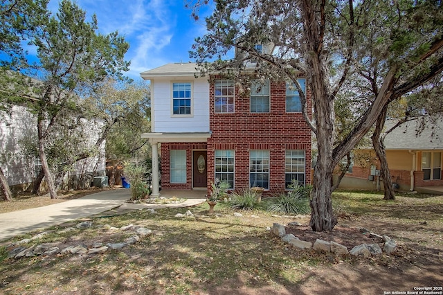 view of front of property featuring brick siding and concrete driveway