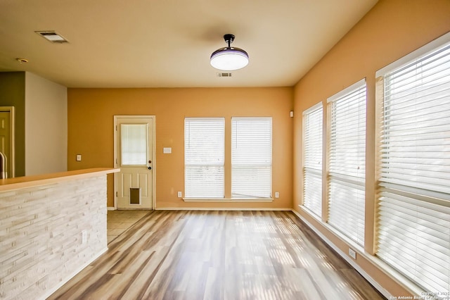 unfurnished living room with visible vents and light wood-type flooring