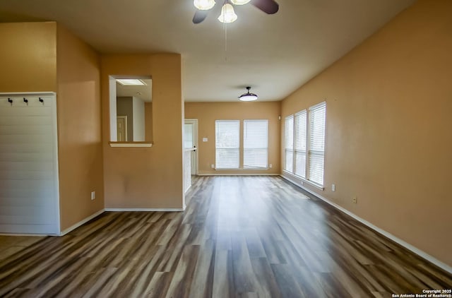 unfurnished living room featuring baseboards, wood finished floors, and ceiling fan