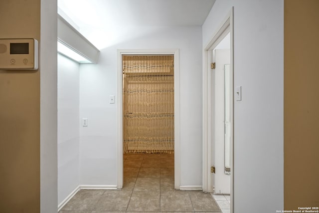 hallway with tile patterned flooring and baseboards