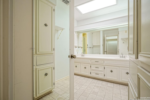 full bathroom featuring a sink, visible vents, double vanity, and tile patterned flooring