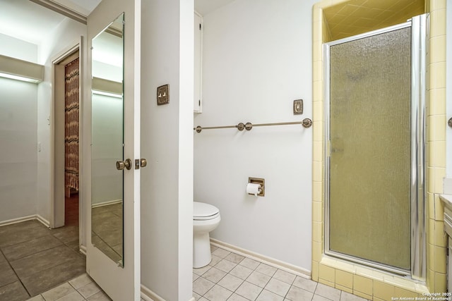 full bathroom featuring tile patterned floors, a stall shower, toilet, and baseboards