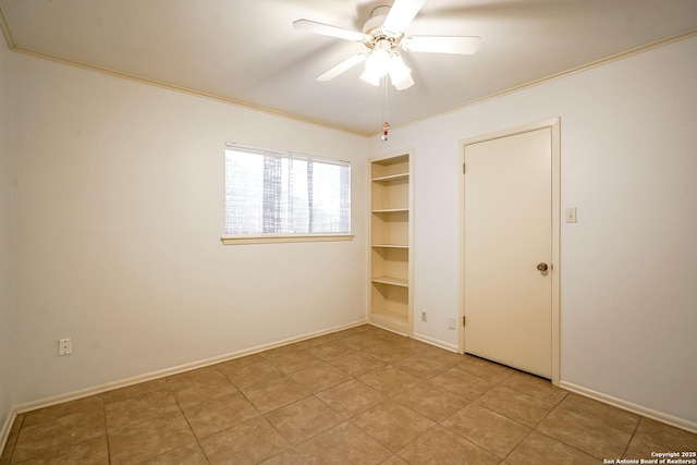 unfurnished room with built in features, baseboards, crown molding, and a ceiling fan