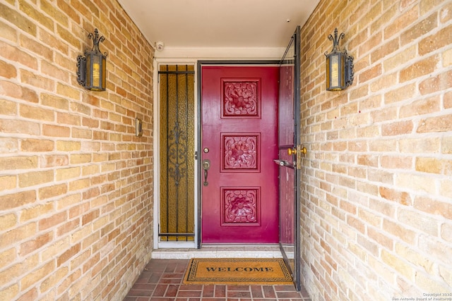 doorway to property featuring brick siding