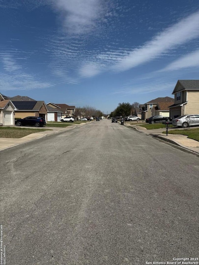 view of road with sidewalks, curbs, and a residential view