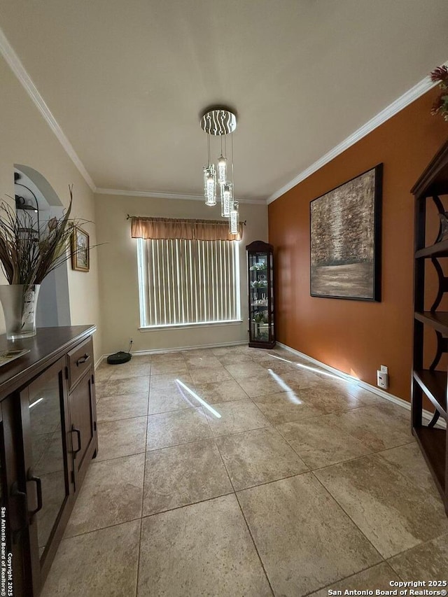 dining space featuring an inviting chandelier, crown molding, and baseboards