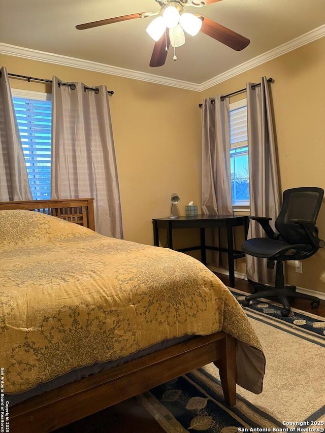 bedroom featuring crown molding, wood finished floors, baseboards, and ceiling fan