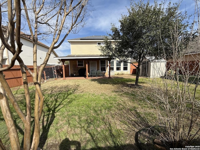 view of yard with a patio, fence, an outdoor structure, and a shed