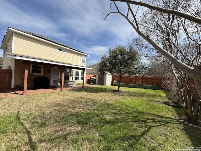 view of yard with an outbuilding, a fenced backyard, a storage shed, and a patio