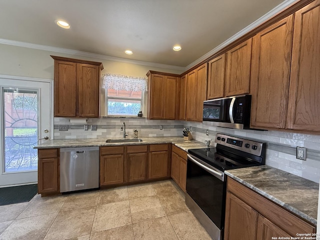 kitchen featuring a sink, ornamental molding, brown cabinetry, and stainless steel appliances