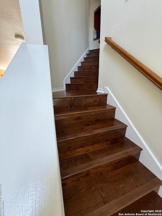 staircase featuring arched walkways