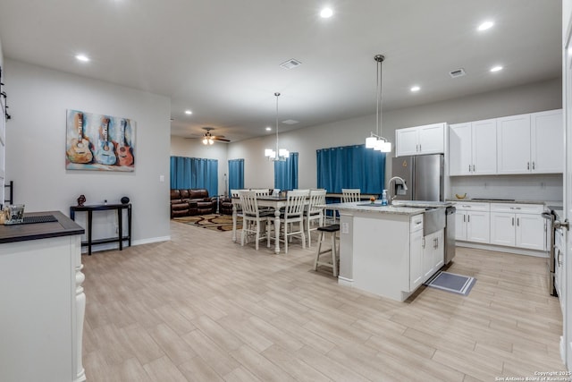 kitchen with open floor plan, light wood-type flooring, visible vents, and stainless steel appliances