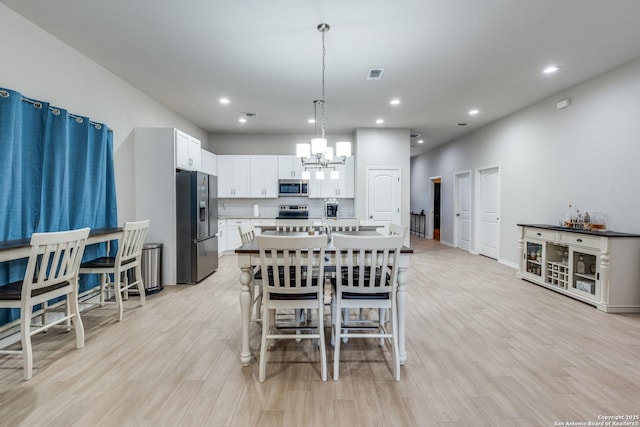 dining area featuring a chandelier, visible vents, recessed lighting, and light wood finished floors