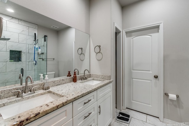 bathroom featuring a stall shower, toilet, marble finish floor, and a sink