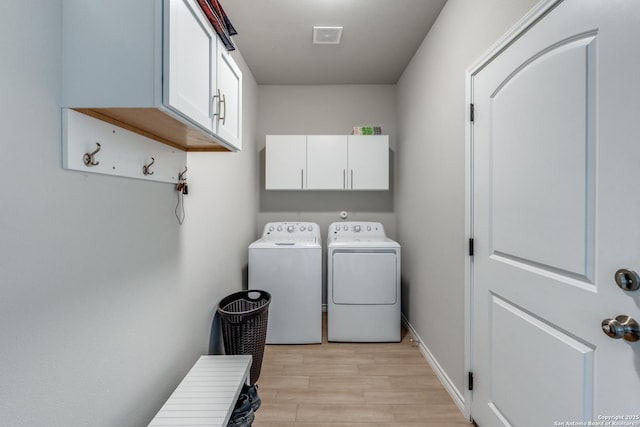 laundry room featuring visible vents, baseboards, light wood-style flooring, cabinet space, and independent washer and dryer