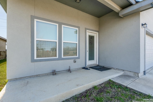 doorway to property featuring stucco siding