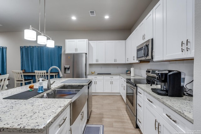 kitchen featuring stainless steel appliances, backsplash, visible vents, and white cabinets