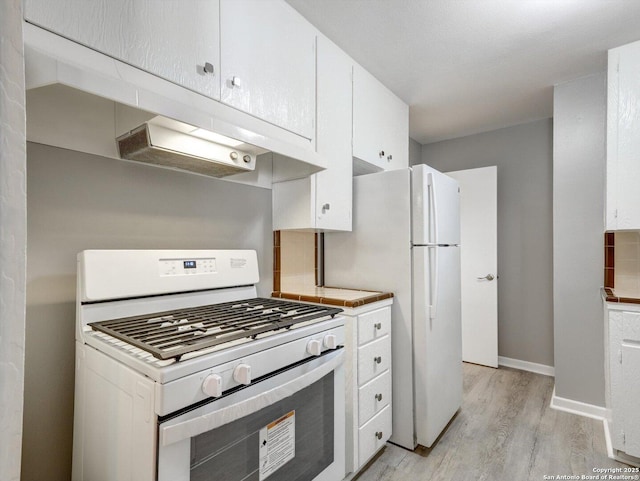 kitchen with white appliances, baseboards, light countertops, white cabinets, and light wood-style floors