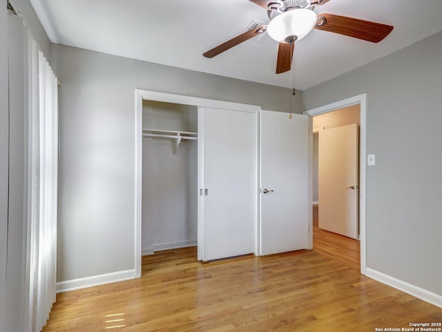 unfurnished bedroom with a closet, baseboards, light wood-style floors, and ceiling fan