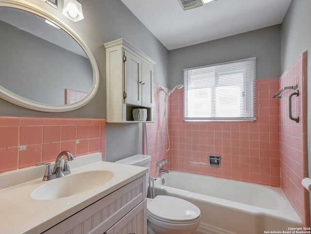 full bathroom featuring visible vents, toilet, washtub / shower combination, and vanity