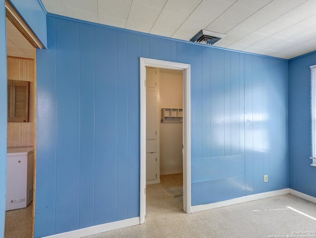 unfurnished bedroom featuring visible vents, fridge, and baseboards