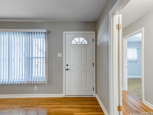 foyer entrance featuring baseboards and wood finished floors