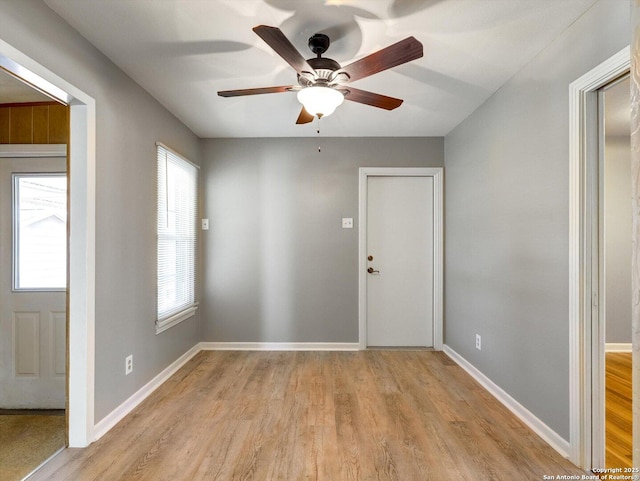 foyer entrance with baseboards, light wood finished floors, and ceiling fan