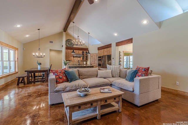 living area featuring a wealth of natural light, concrete floors, and a chandelier