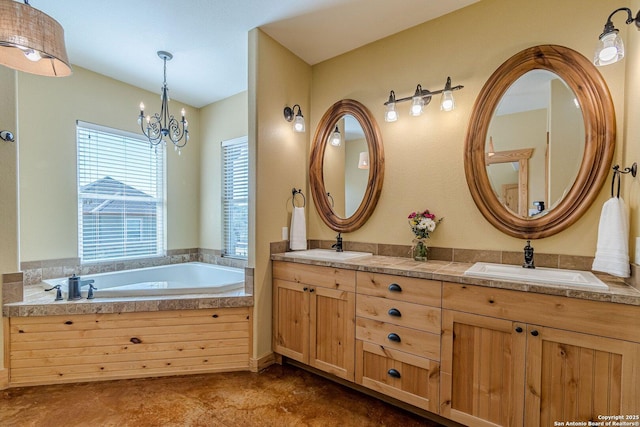 bathroom with a sink, a garden tub, a chandelier, and double vanity