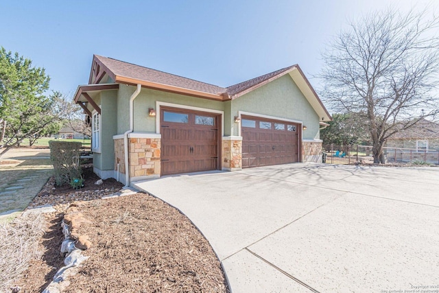 view of home's exterior featuring stucco siding, driveway, stone siding, fence, and a garage