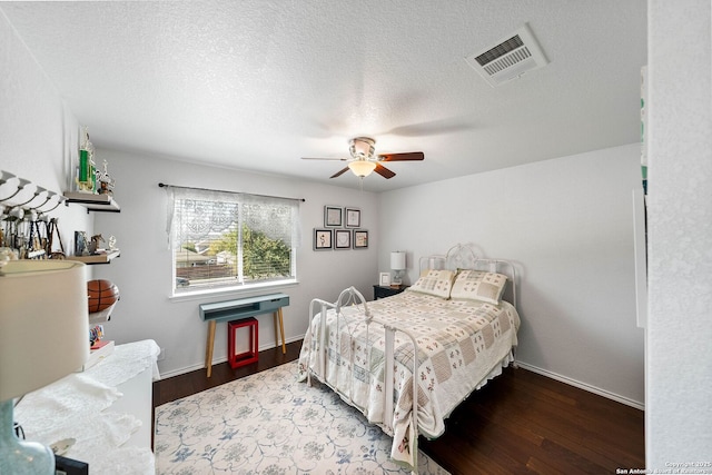 bedroom with baseboards, wood finished floors, visible vents, and ceiling fan